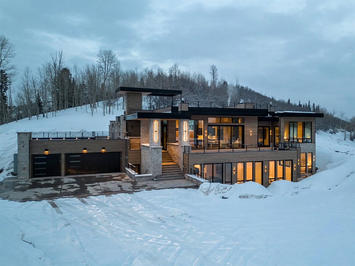 mountain modern home exterior with snow at dusk