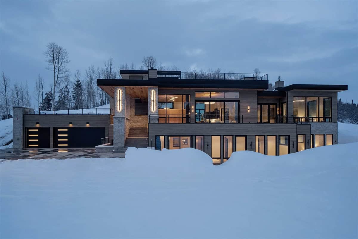 mountain modern home exterior with snow at dusk
