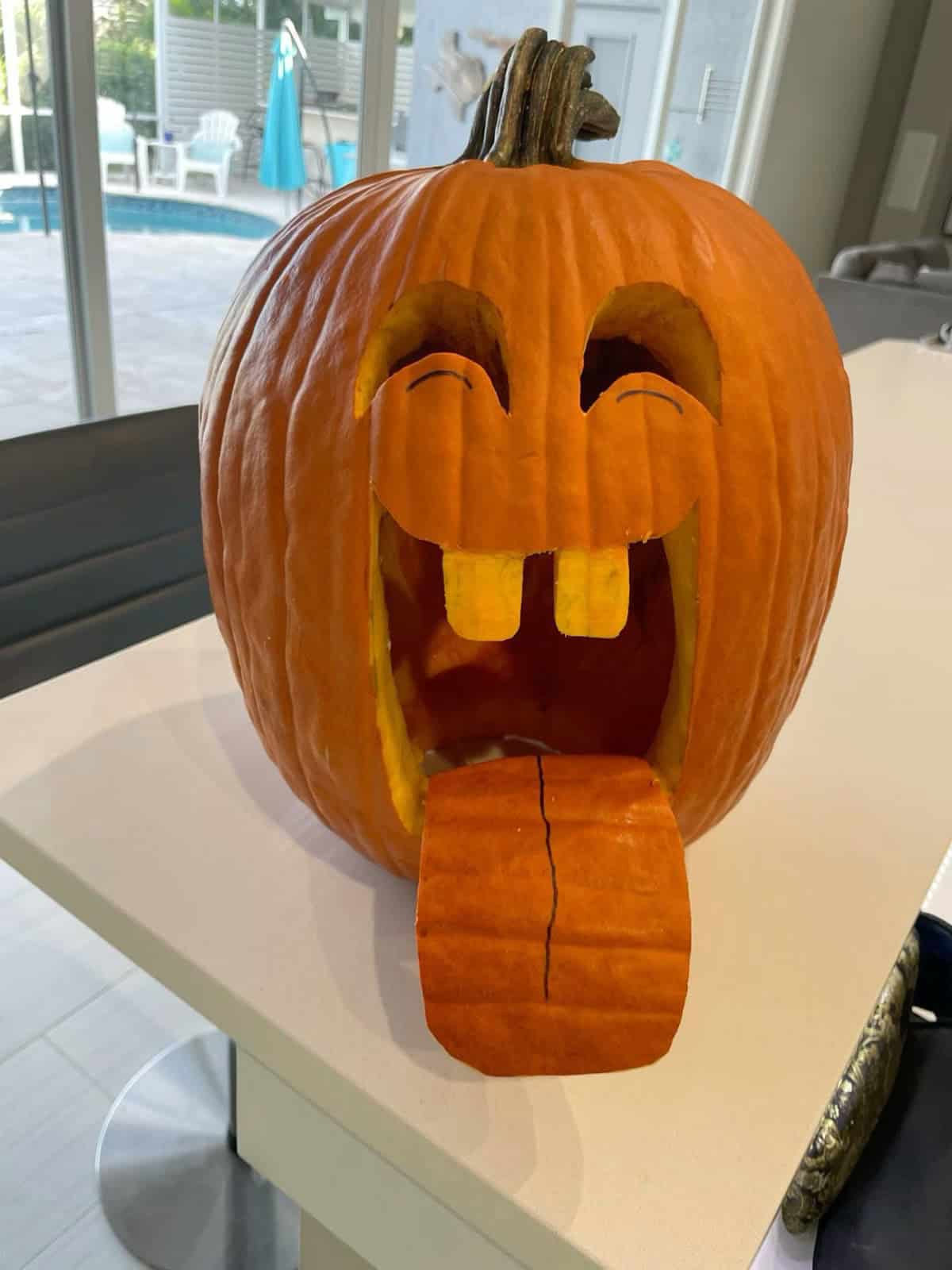 funny carved pumpkin with large tongue sticking out