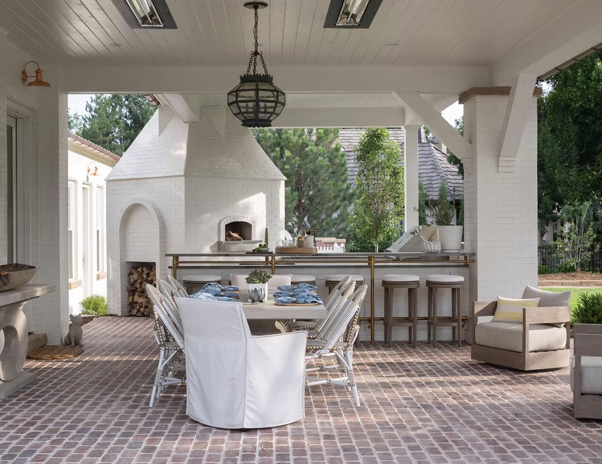 cape-cod inspired home exterior covered porch with an outdoor kitchen