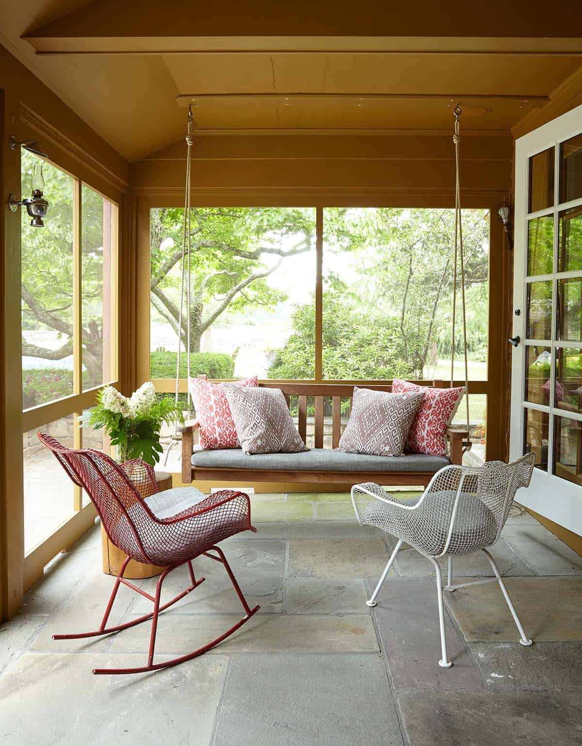 farmhouse style screened in porch with a hanging bed swing
