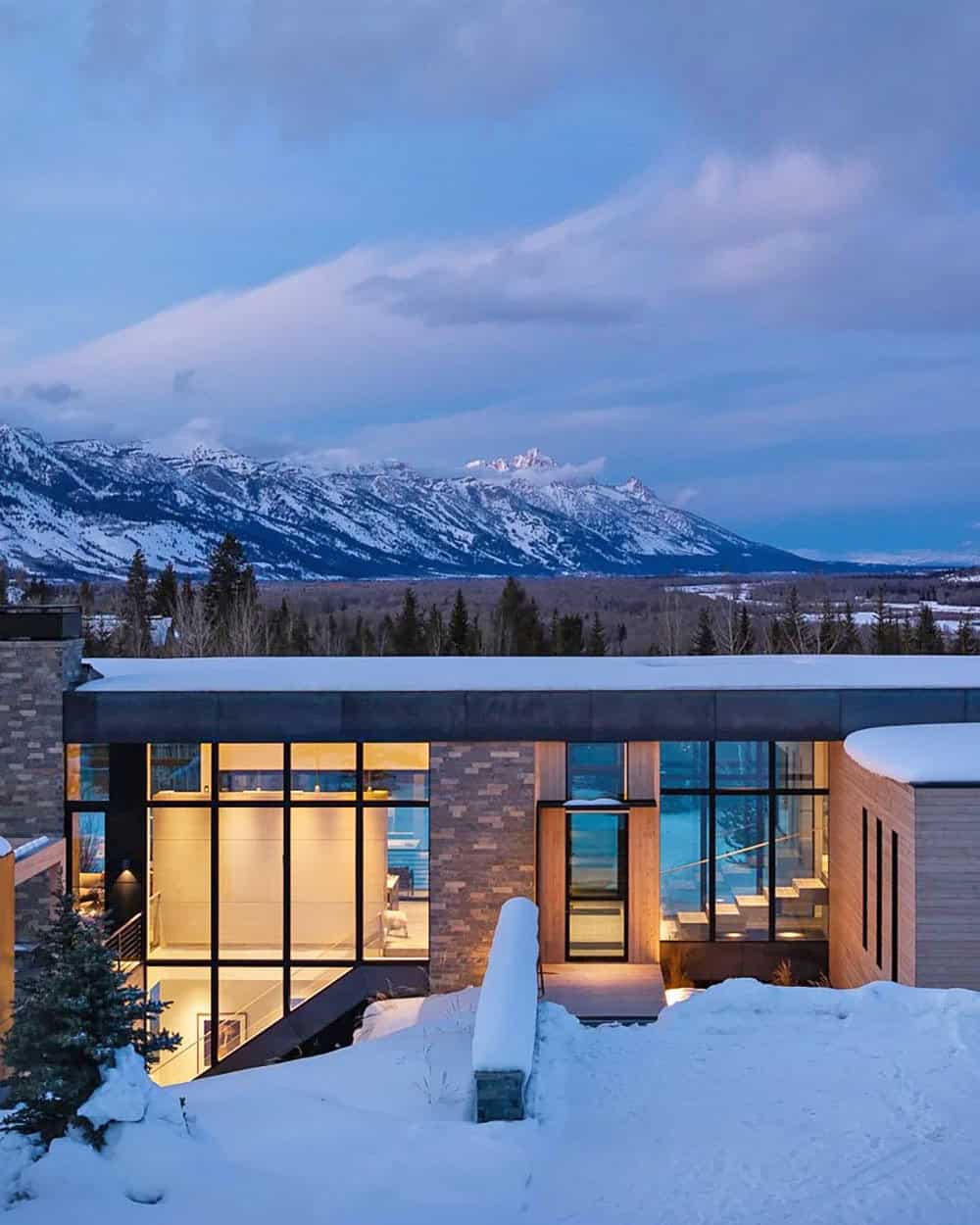 contemporary mountain house exterior with snow at dusk