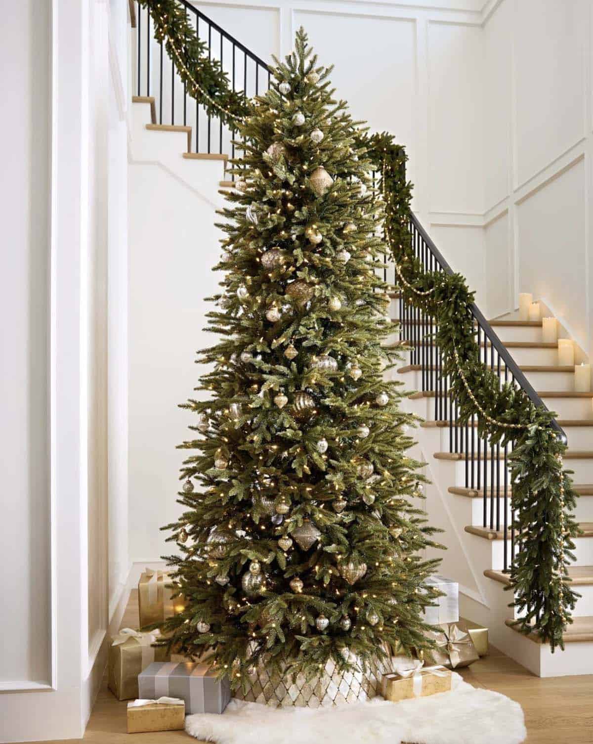 elegant christmas tree in front of a staircase
