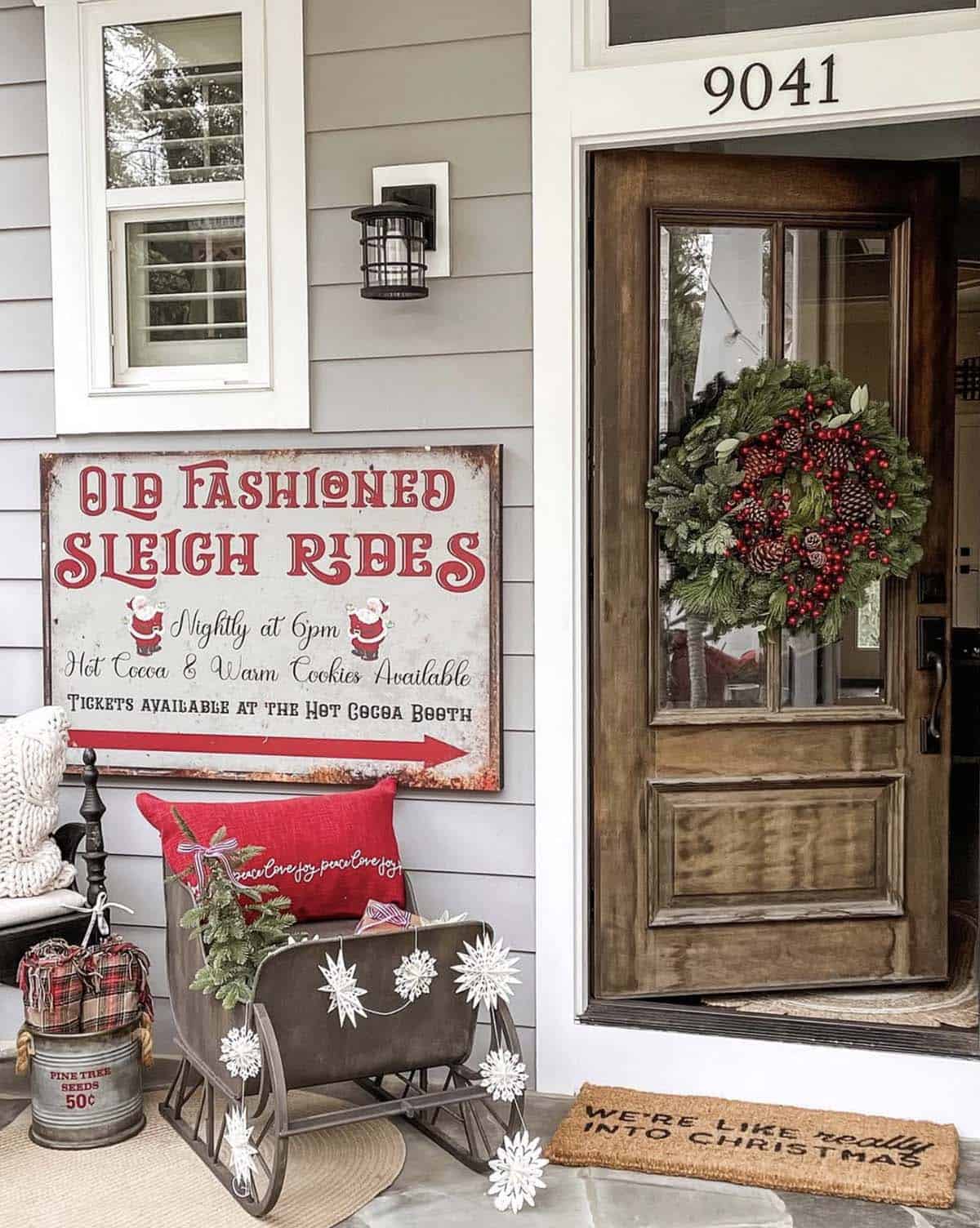 christmas decorated front porch with a metal sleigh