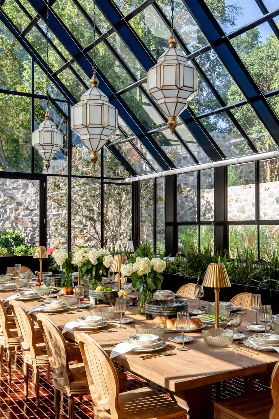 modern glass pavillion with a long dining table