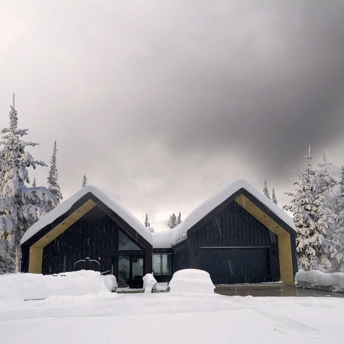 modern scandinavian mountain cabin exterior with snow