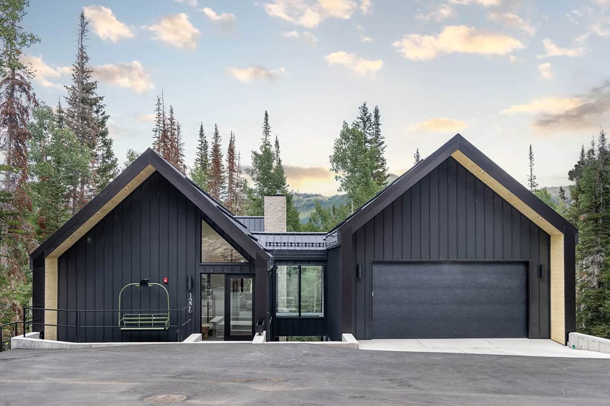 modern scandinavian mountain cabin exterior with snow