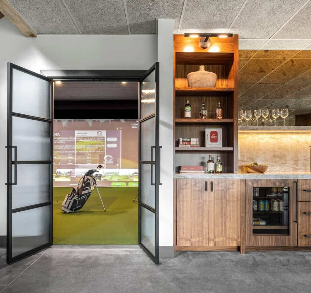 modern wet bar and doors leading into a golf simulator room