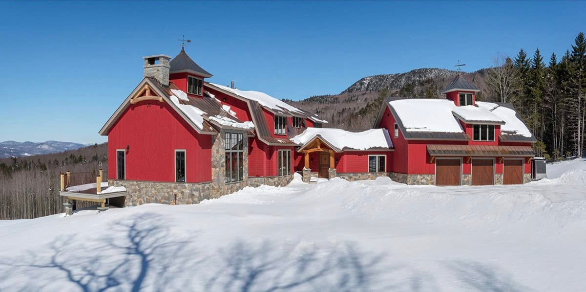 rustic red farmhouse exterior with snow