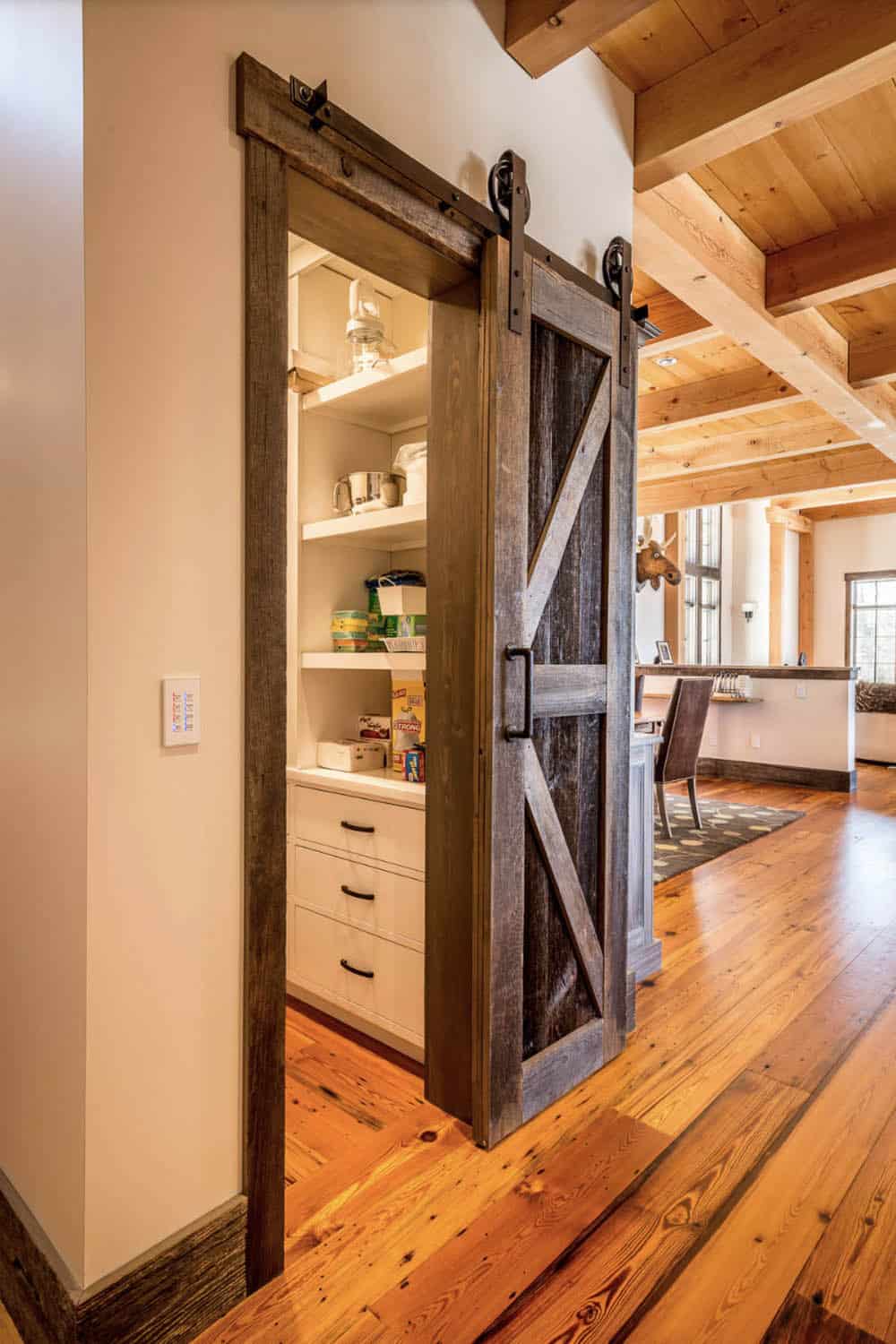 rustic hallway with a sliding barn door leading into a pantry