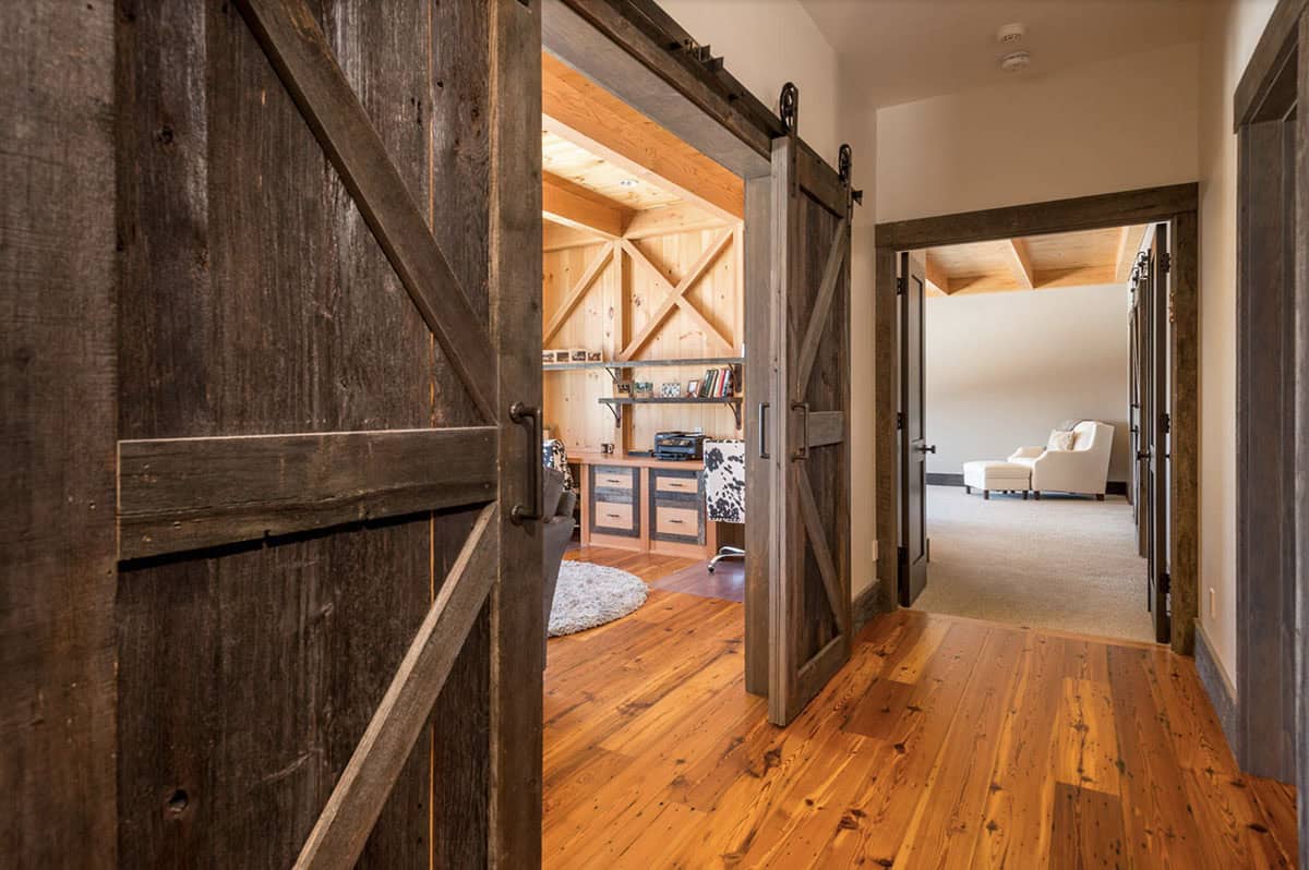rustic hallway with sliding barn doors leading into a home office