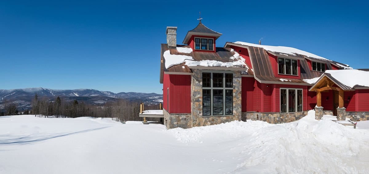 rustic red farmhouse exterior with snow