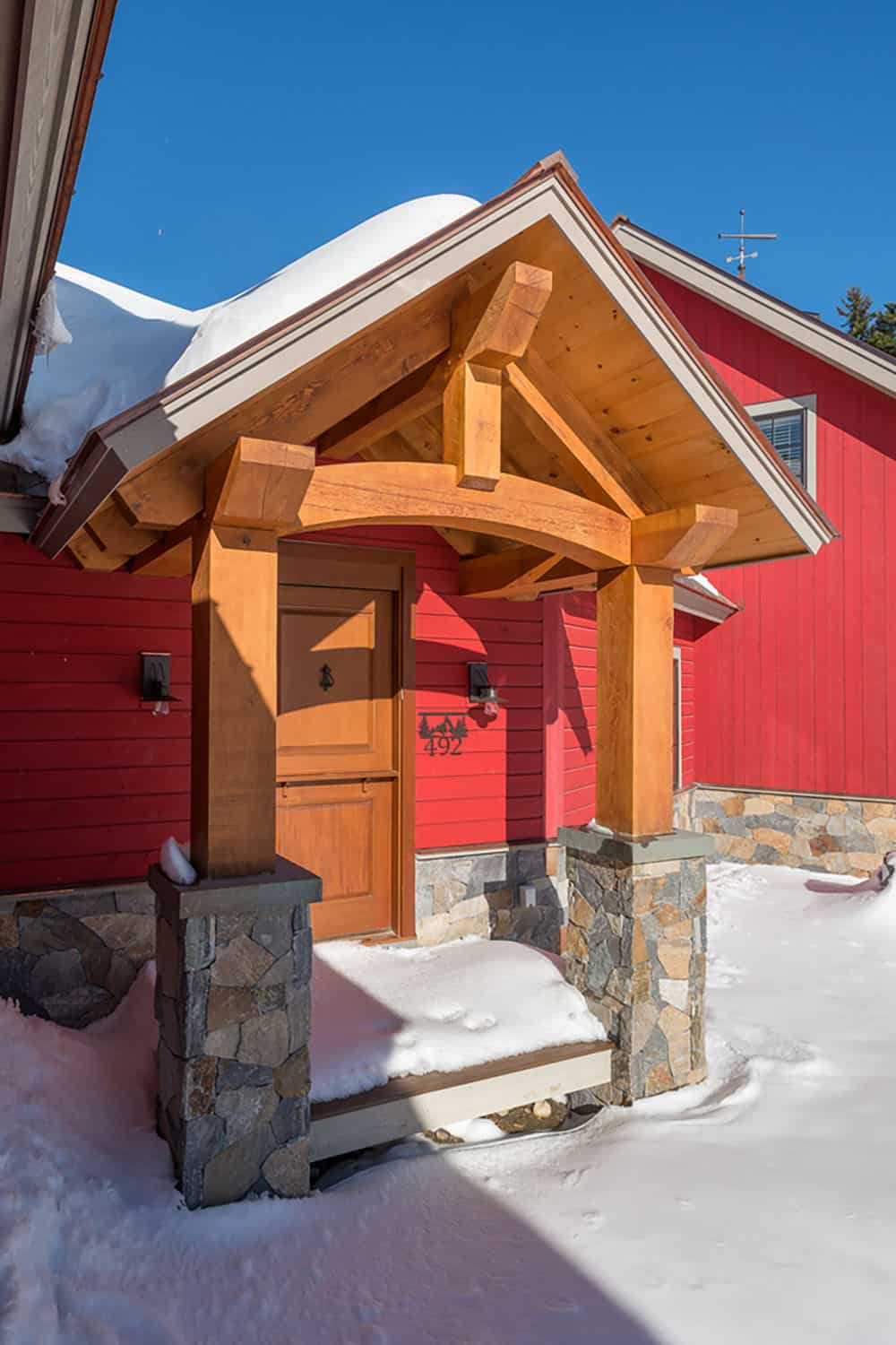 rustic red farmhouse exterior with snow