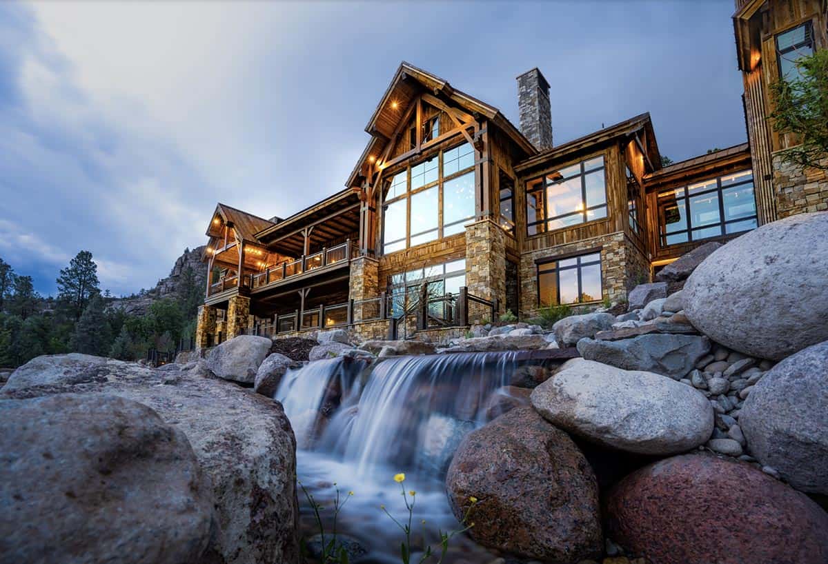 timber frame mountain house exterior with a waterfall
