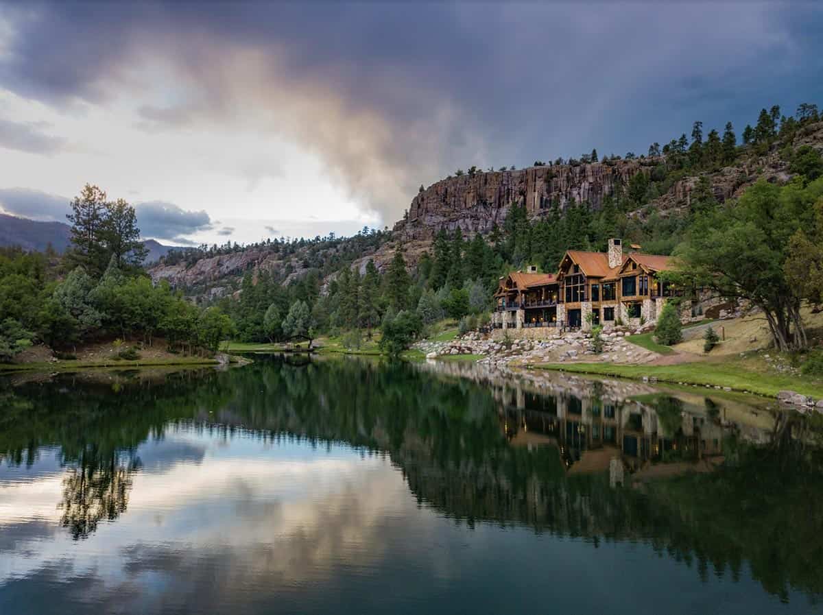 timber frame mountain house exterior with a water view