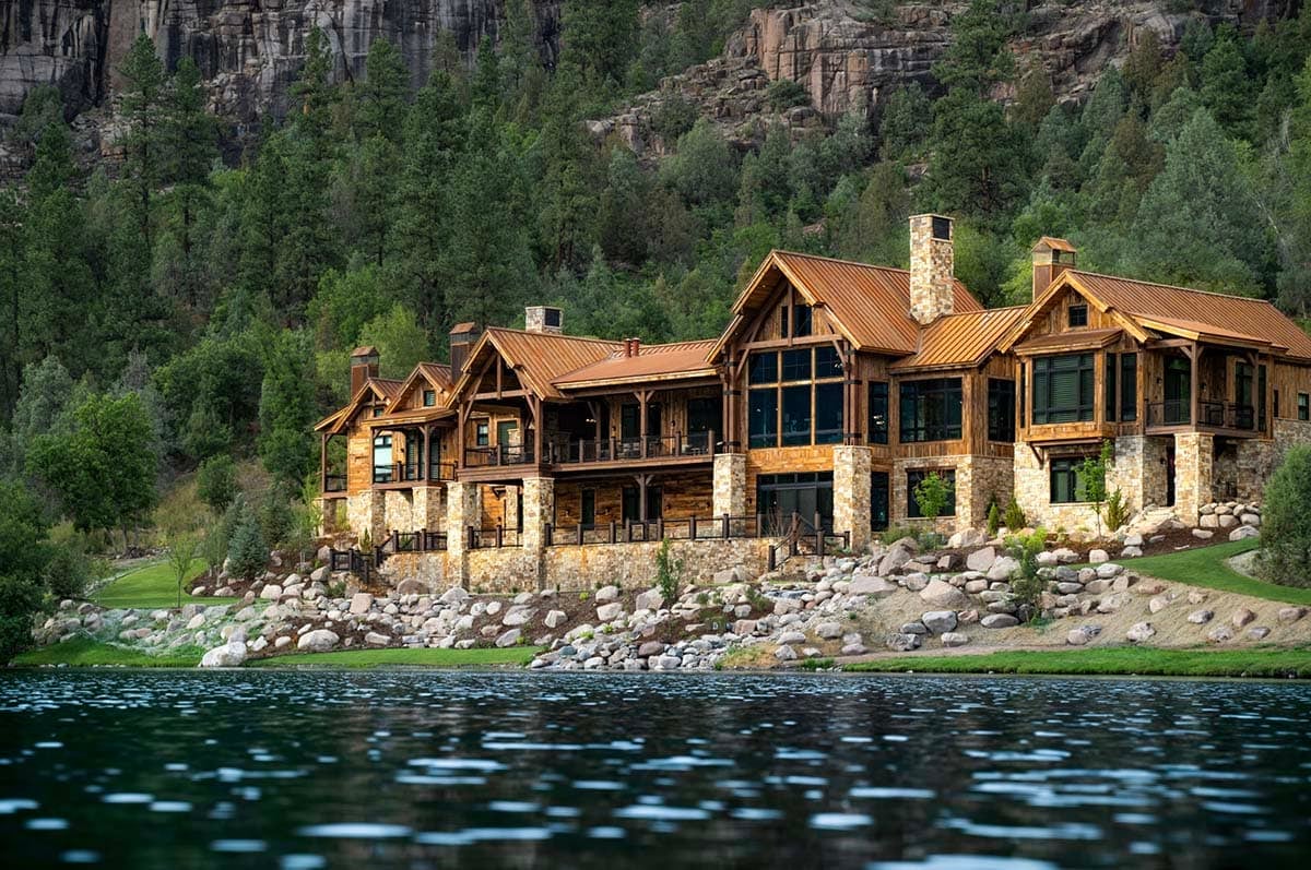 timber frame mountain house exterior with a water view