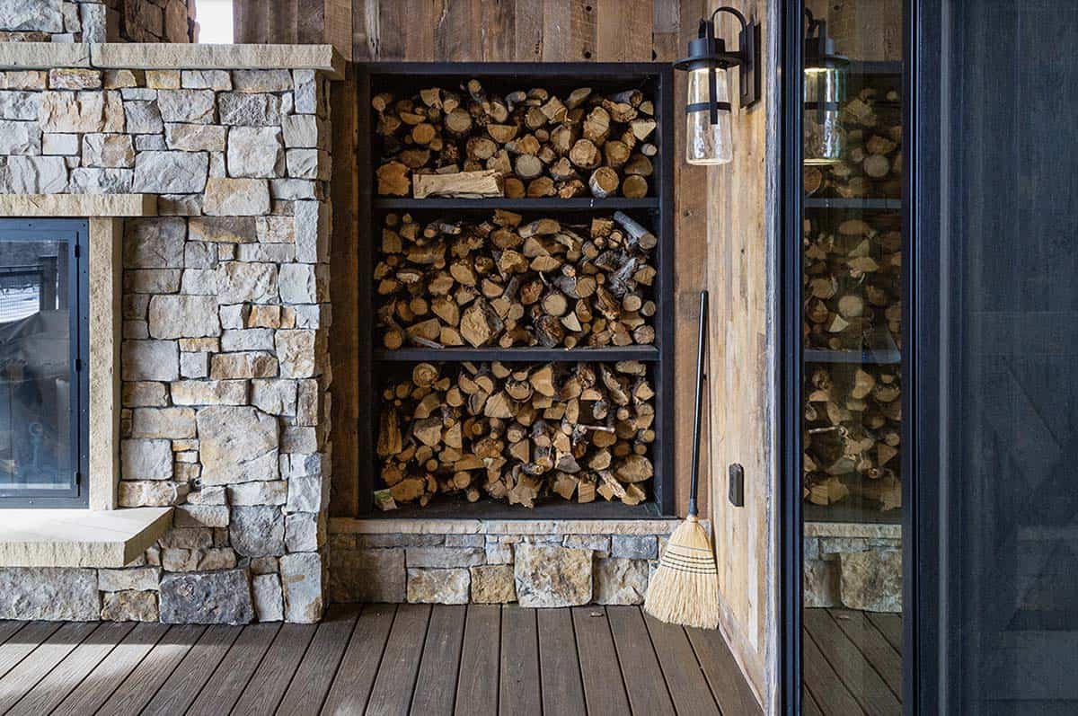 rustic covered patio with a fireplace and firewood storage