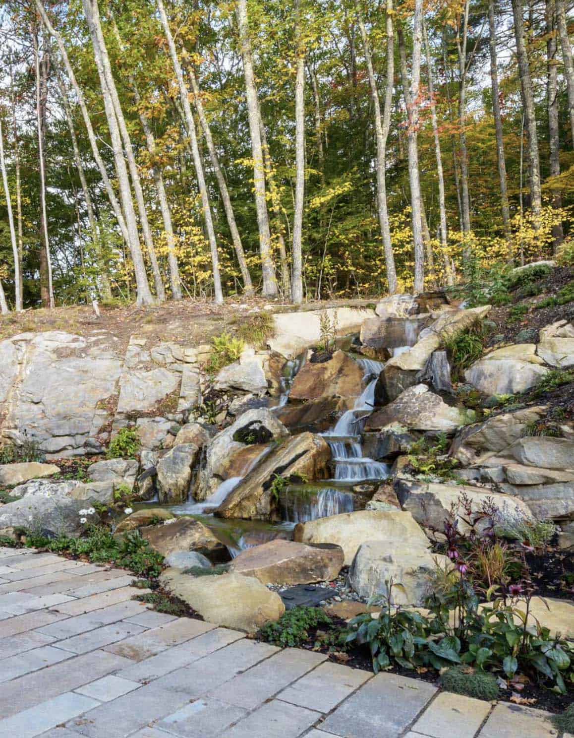 traditiional lake house exterior landscape with a waterfall