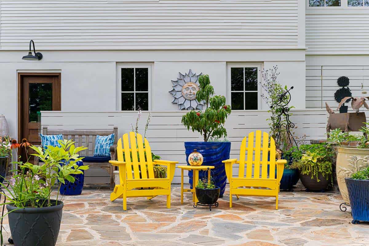 alpine farmhouse exterior backyard patio with yellow adirondack chairs