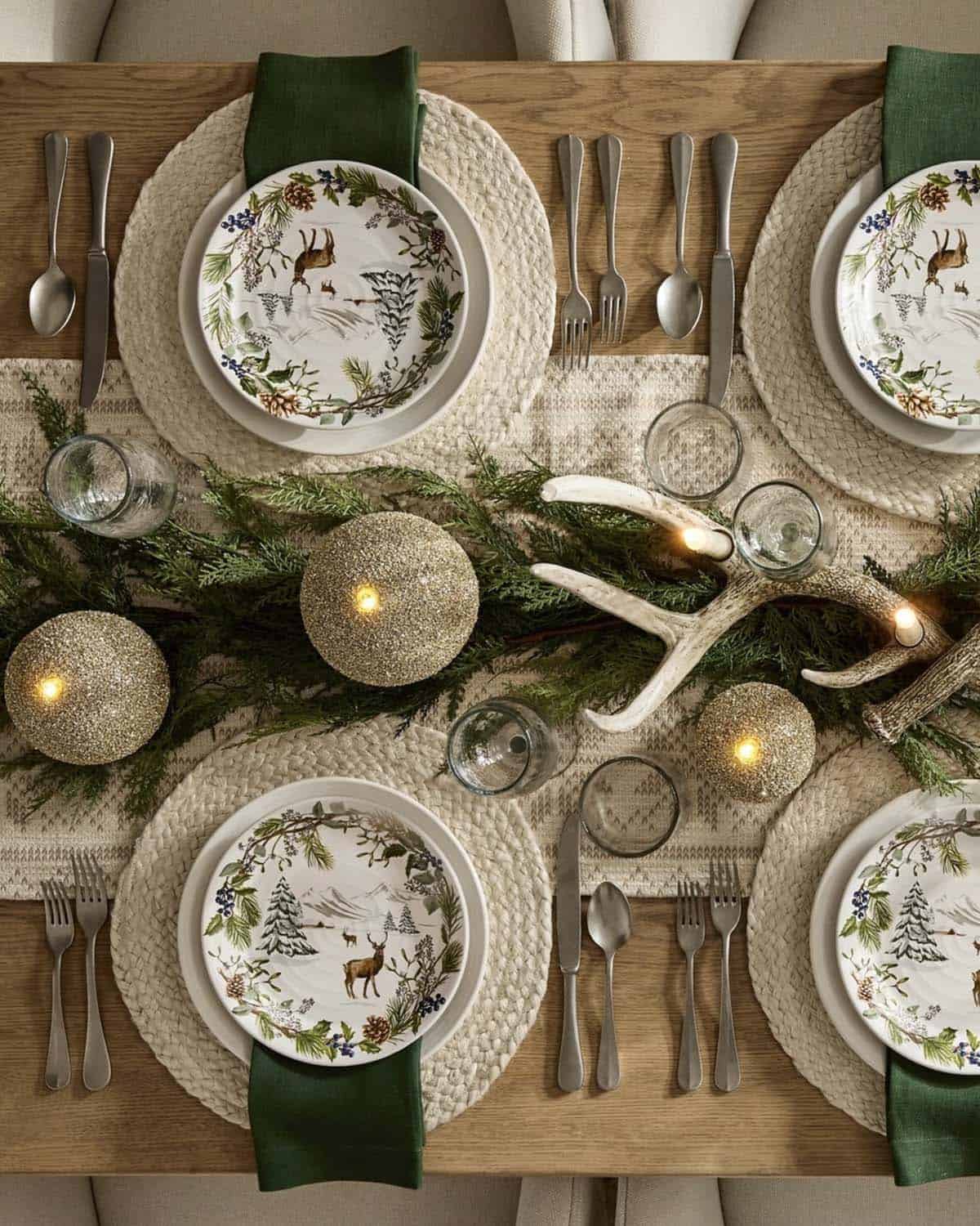 elegant dining table decorated for christmas with greenery and candles