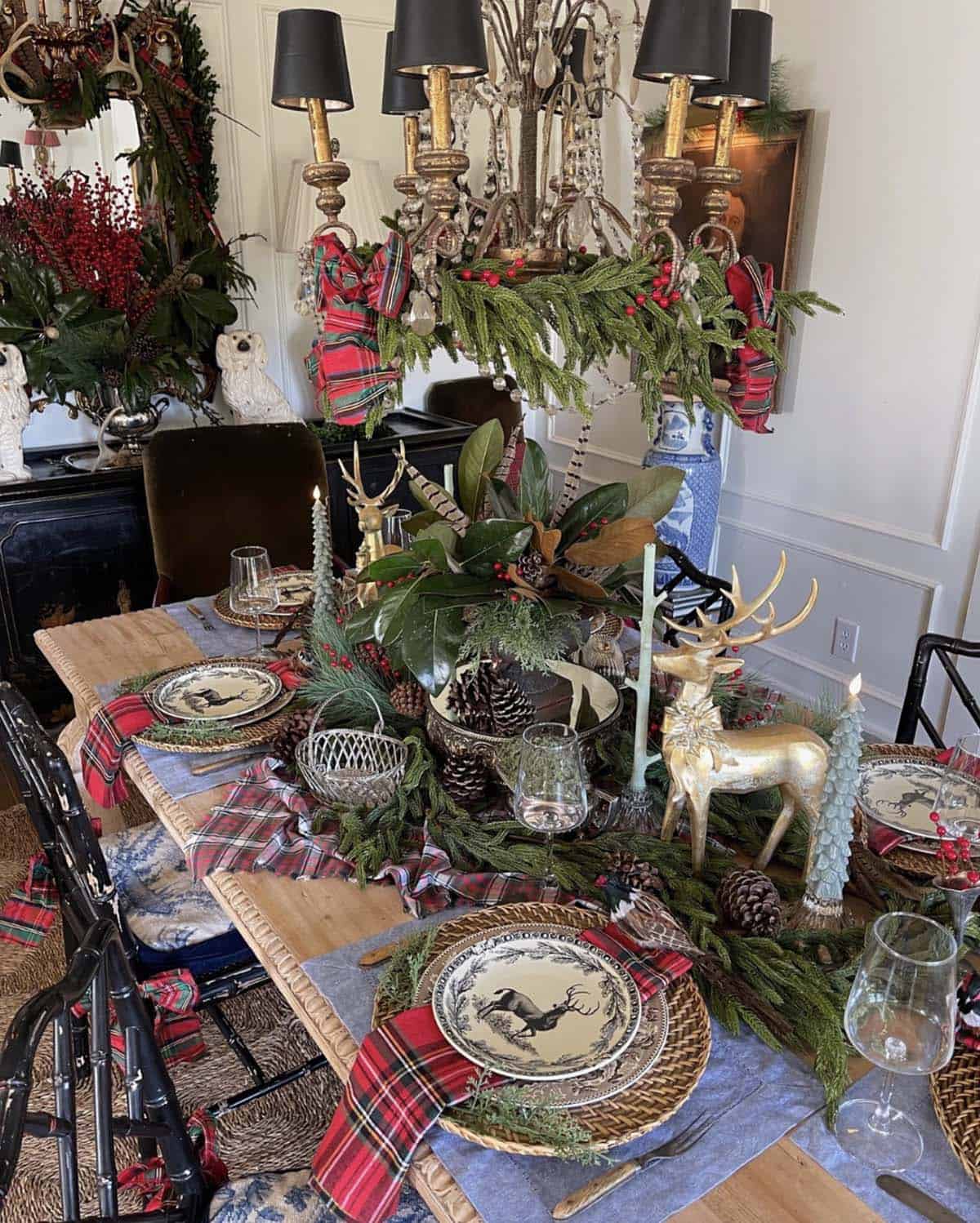 elegant holiday table with rich metallics, sculptural deer silhouettes, and evergreens