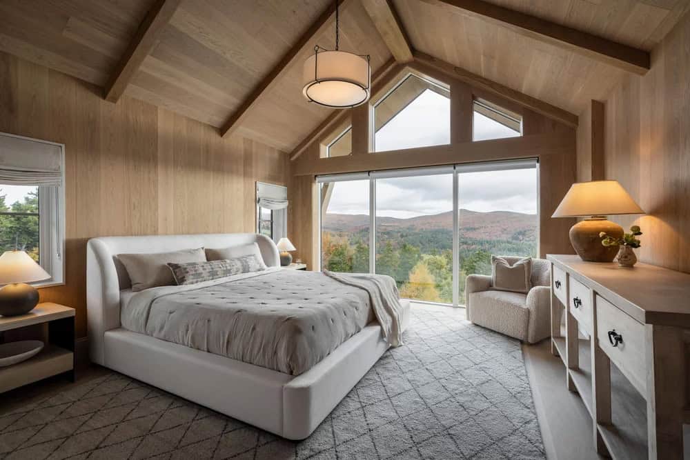 modern bedroom with a large window and mountain views