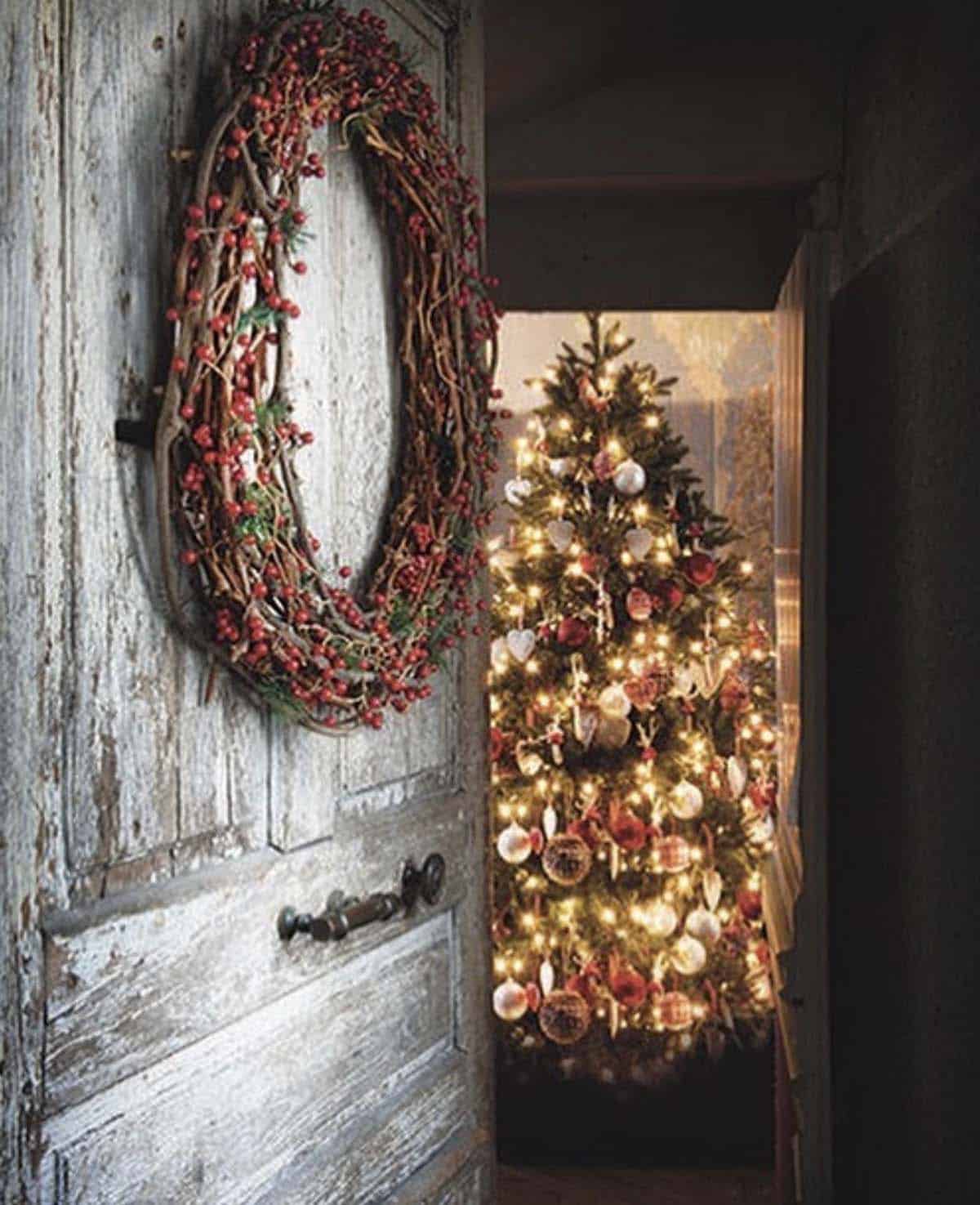 front door with a wreath and view of a christmas tree