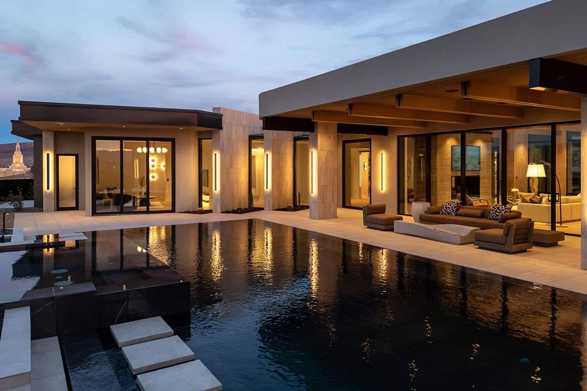 modern desert home exterior with a pool at dusk