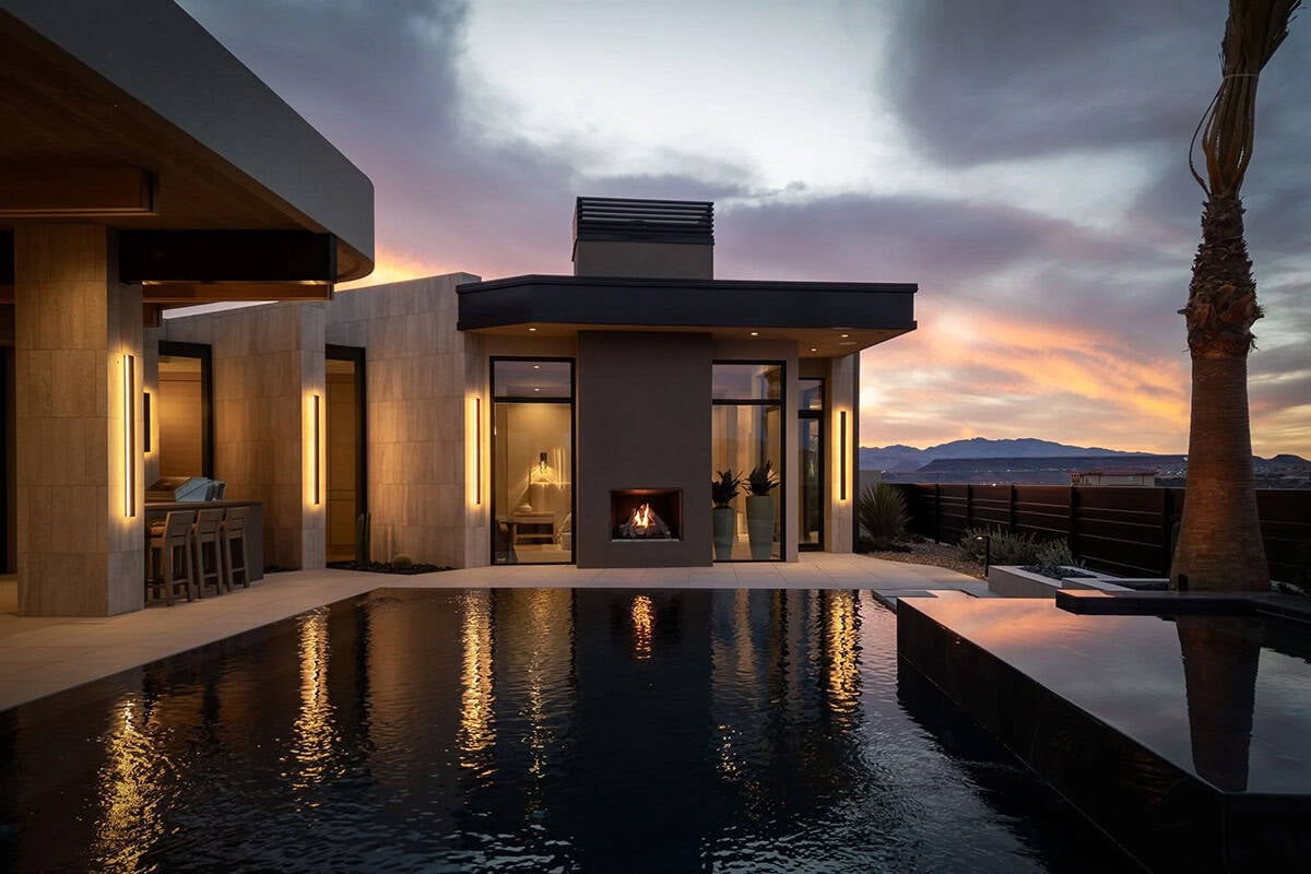 modern desert home exterior with a pool at dusk