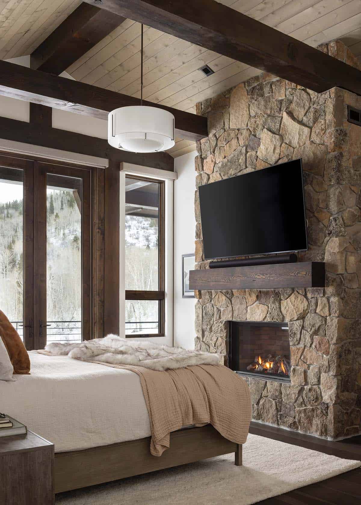 modern mountain style bedroom with a fireplace