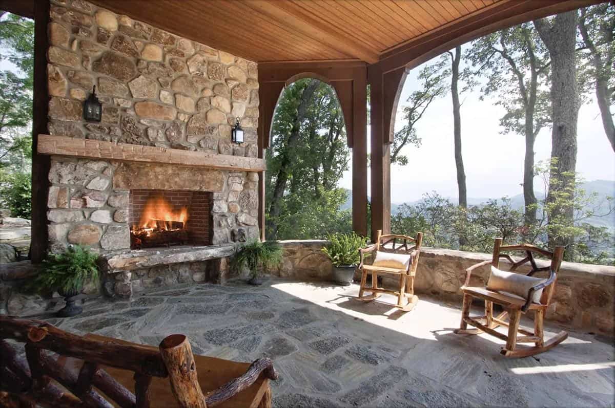 mountain rustic home exterior covered patio with a fireplace