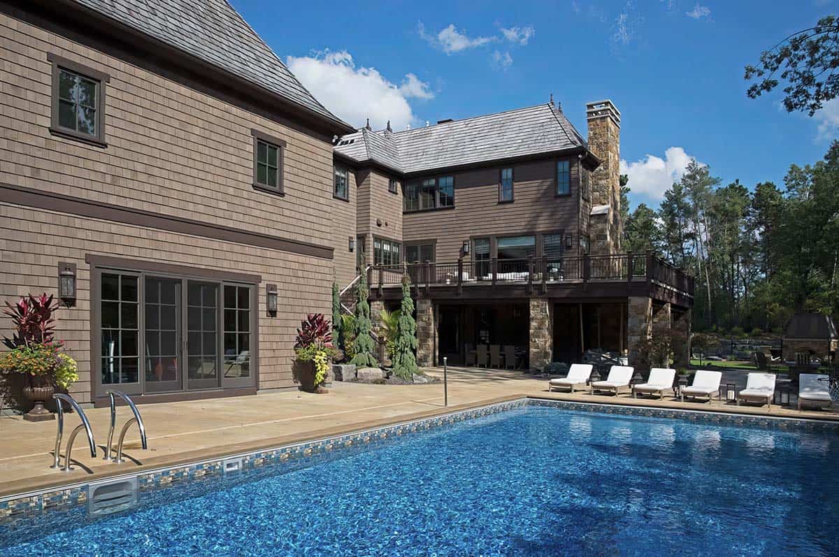 old world lodge style home exterior with a pool