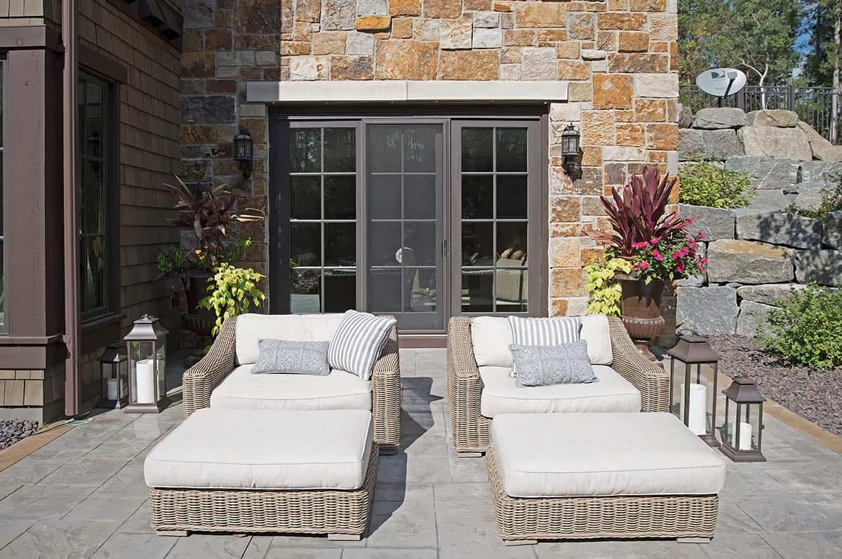 old world lodge style home exterior patio with chaise lounges