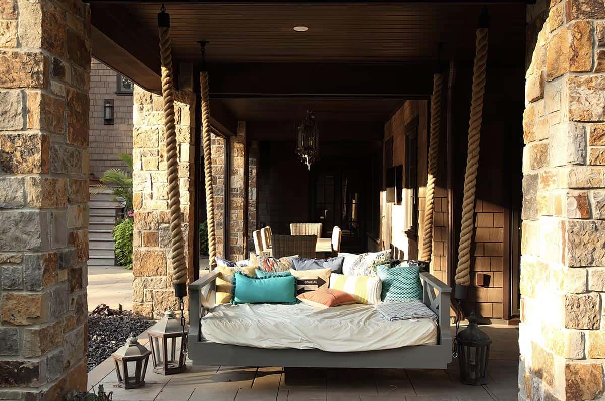 old world lodge style home exterior patio with a hanging daybed