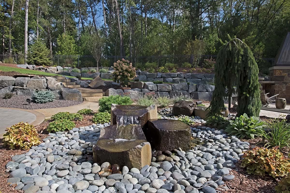 old world lodge style home exterior patio with a water feature
