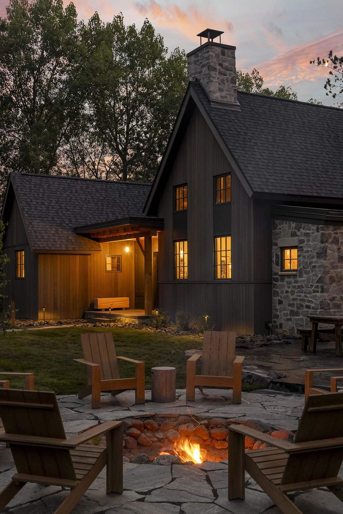 rustic modern lake house exterior patio with a fire pit at dusk