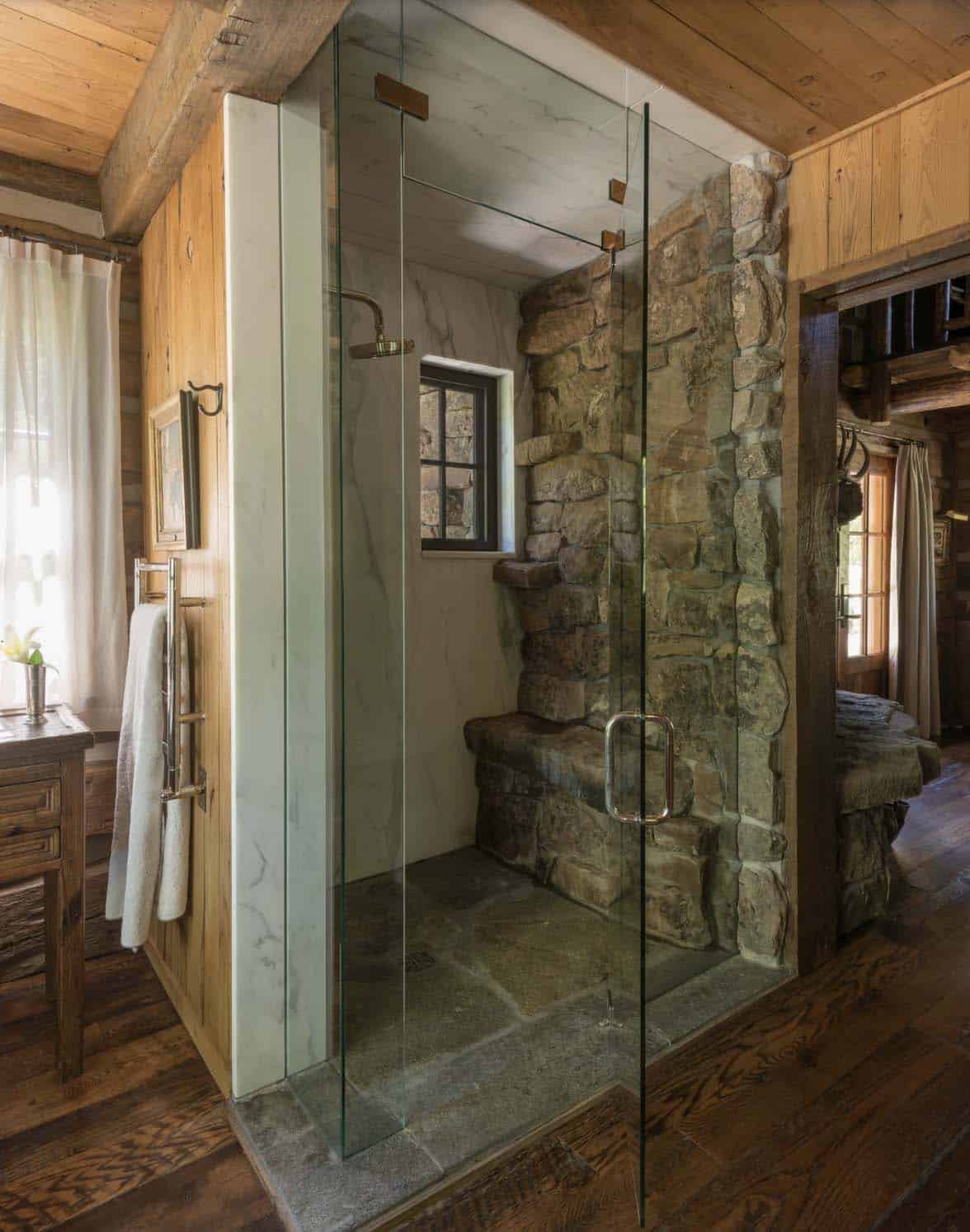  rustic bathroom with a shower and stone wall