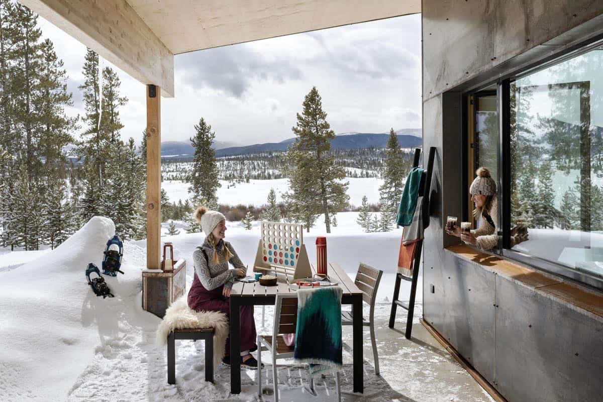 modern mountain home patio with a pass through window and snow