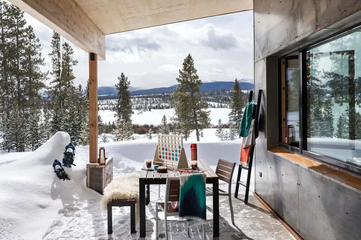 modern mountain home patio with outdoor furniture and snow