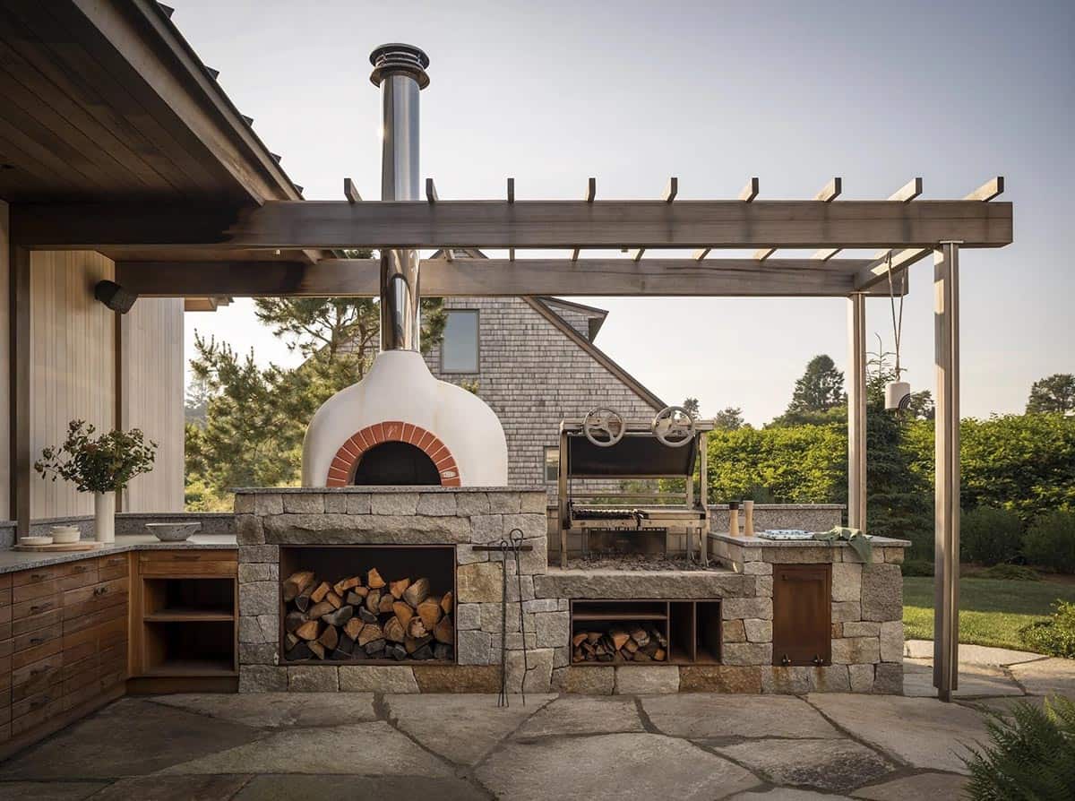 beach style patio with an outdoor kitchen and pizza oven