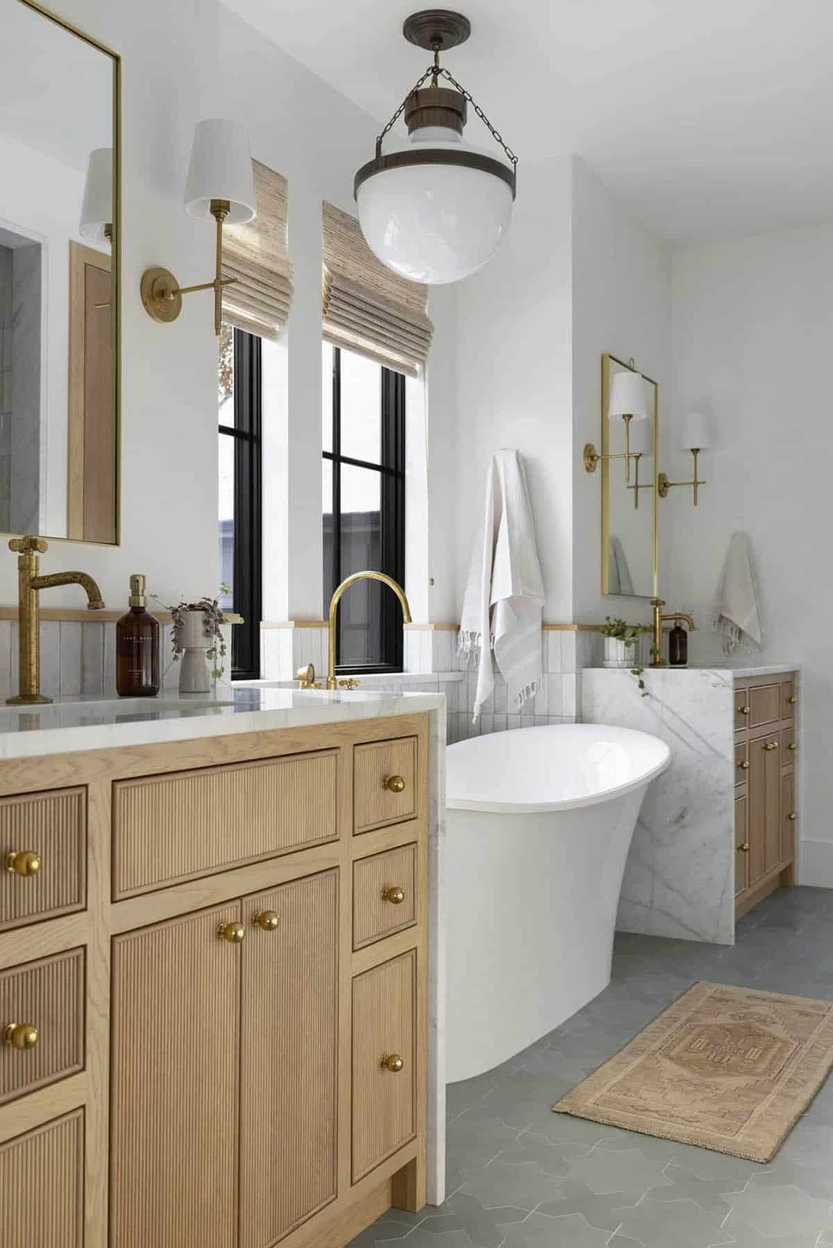 transitional style bathroom with dual vanities and a freestanding tub