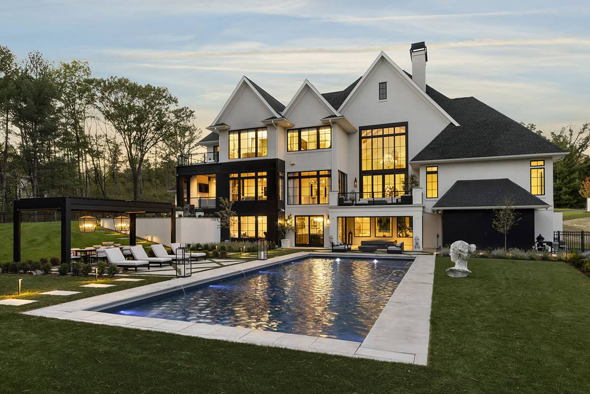 French chateau-inspired home exterior backyard view with a pool