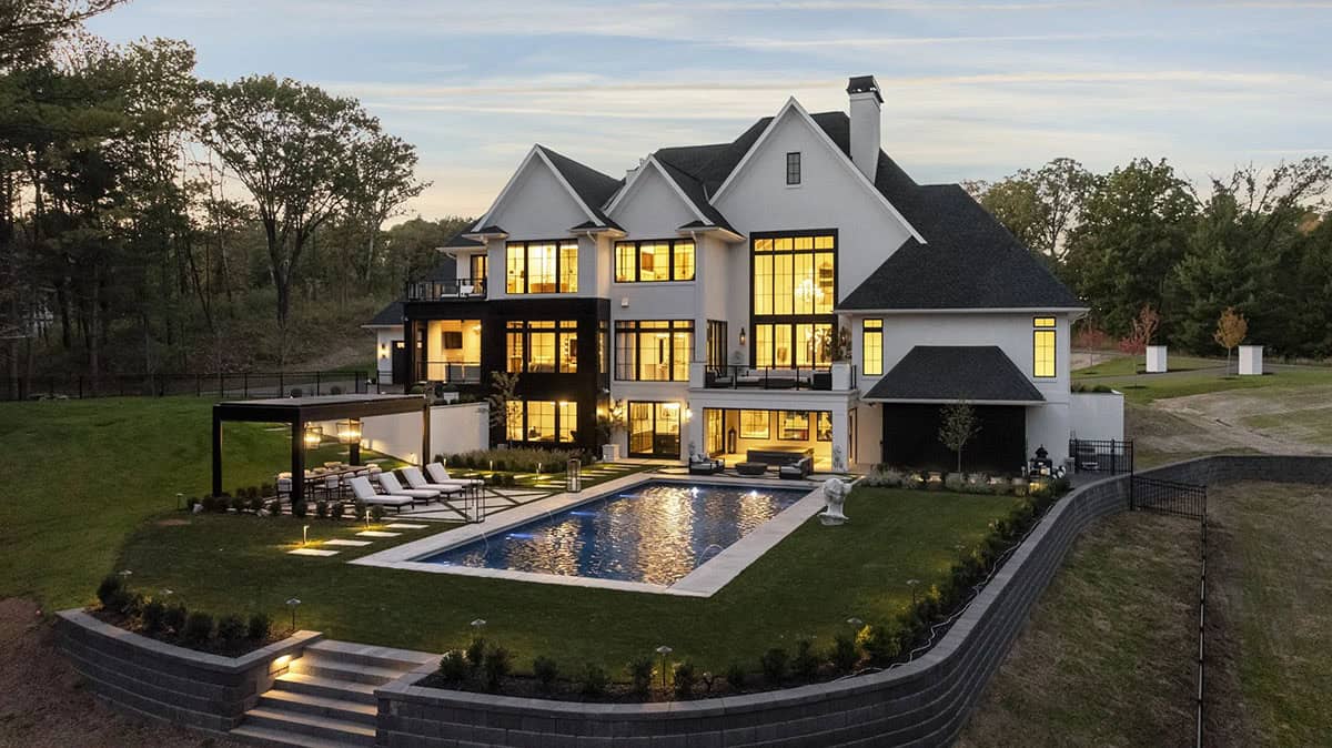 French chateau-inspired home exterior backyard view with a pool
