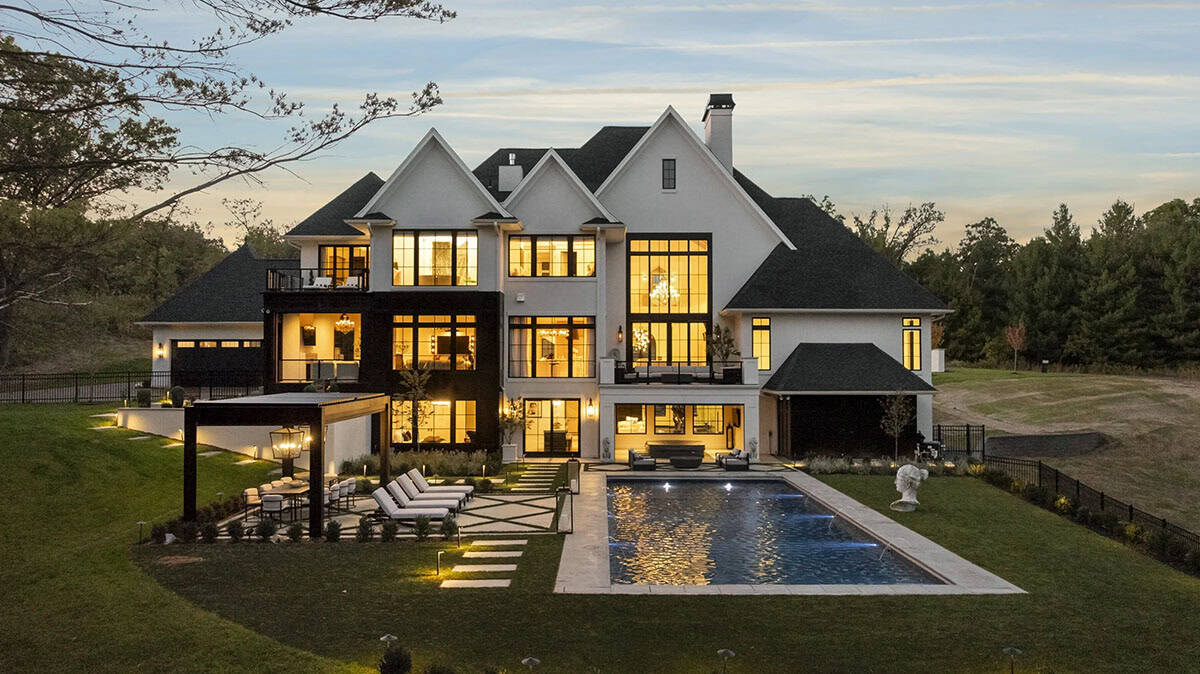 French chateau-inspired home exterior backyard view with a pool