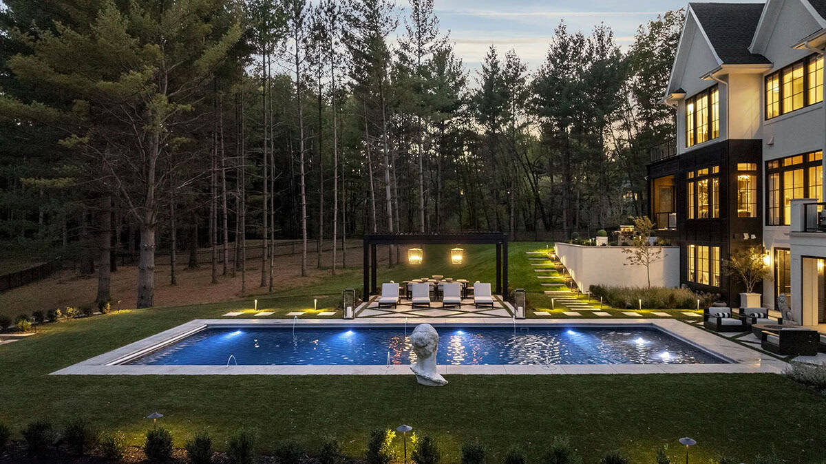 French chateau-inspired home exterior backyard view with a pool