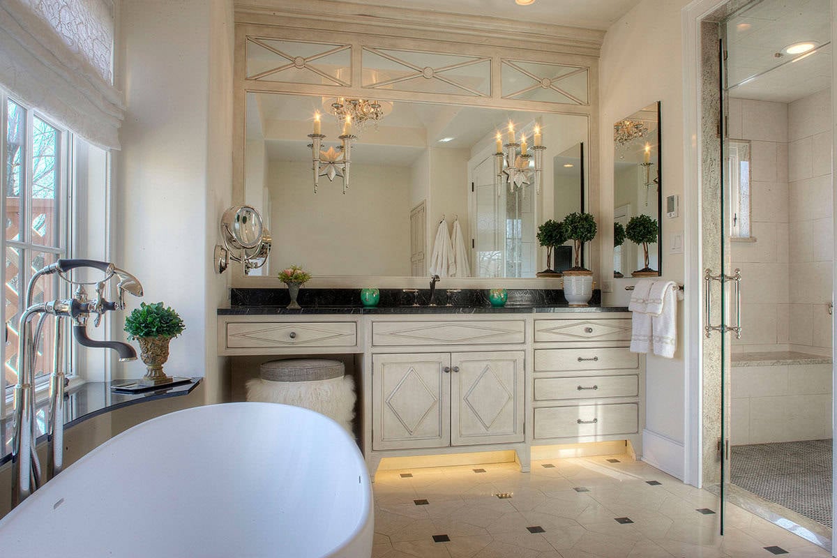 Bathroom with double vanity, black countertop, and elegant decor.