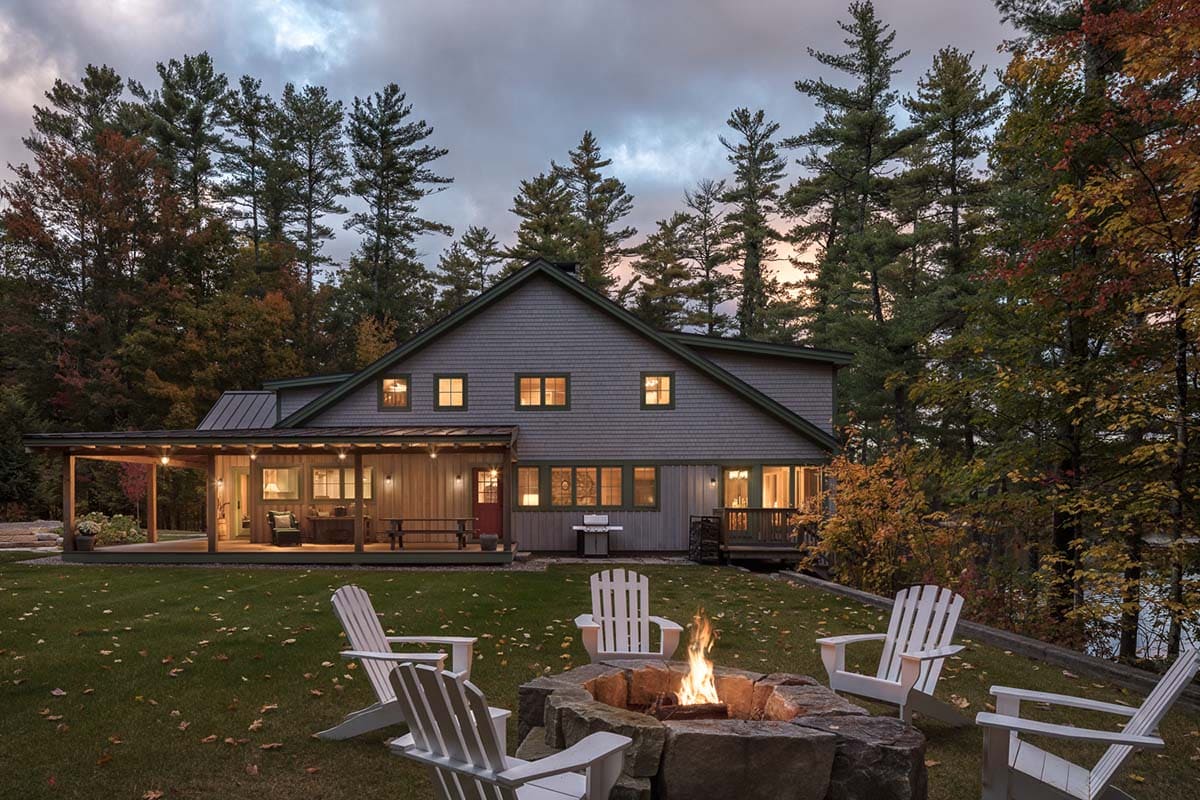 lake house exterior with a fire pit at dusk