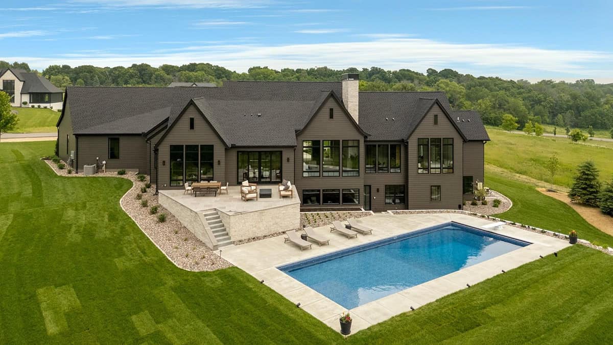 rambler style house exterior with a pool