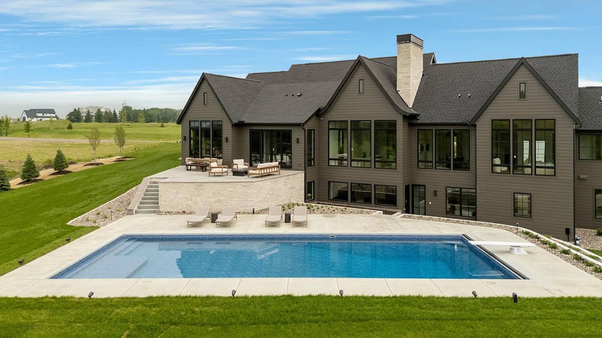 rambler style house exterior with a pool