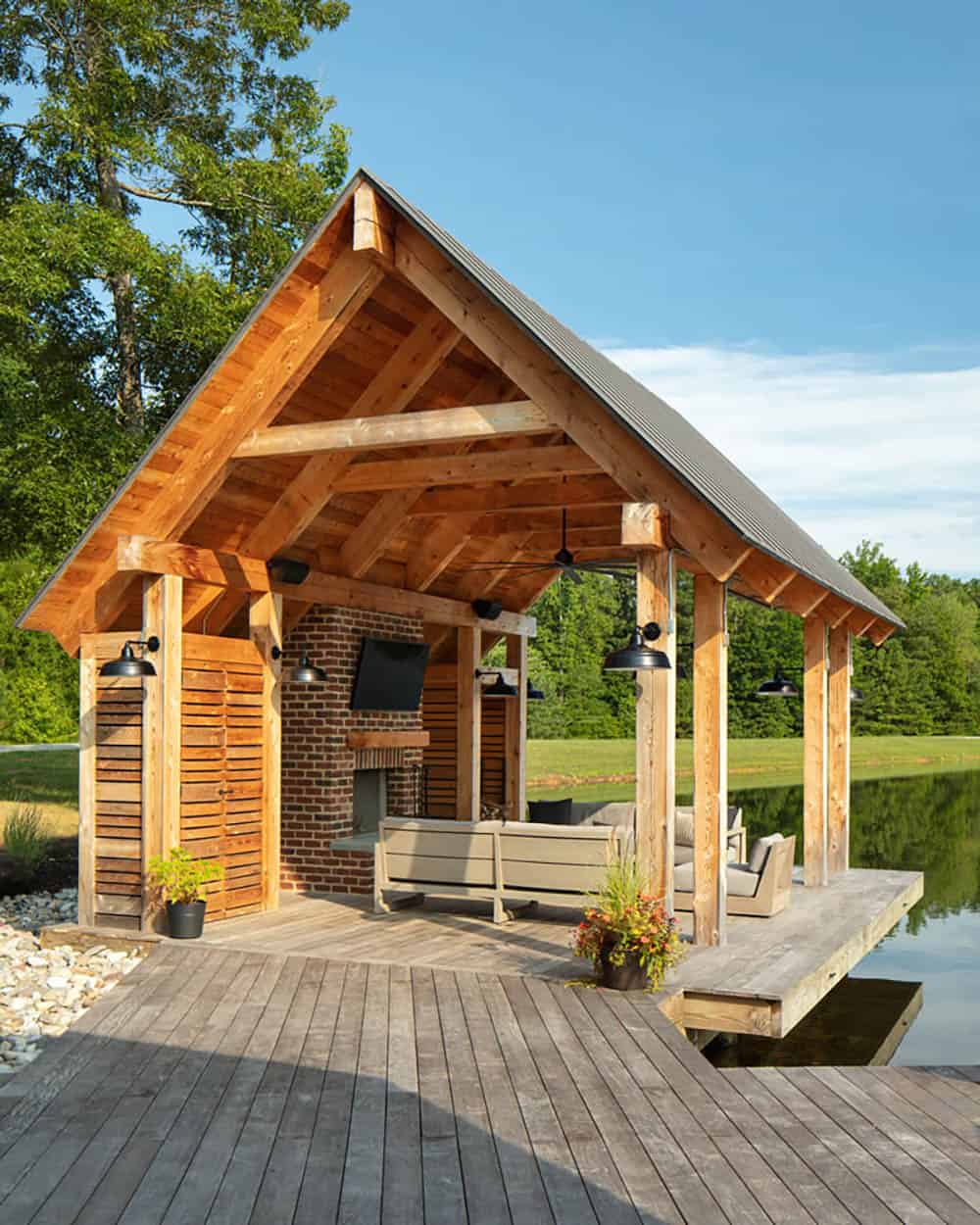 modern farmhouse exterior with a lakeside dock and outdoor dining